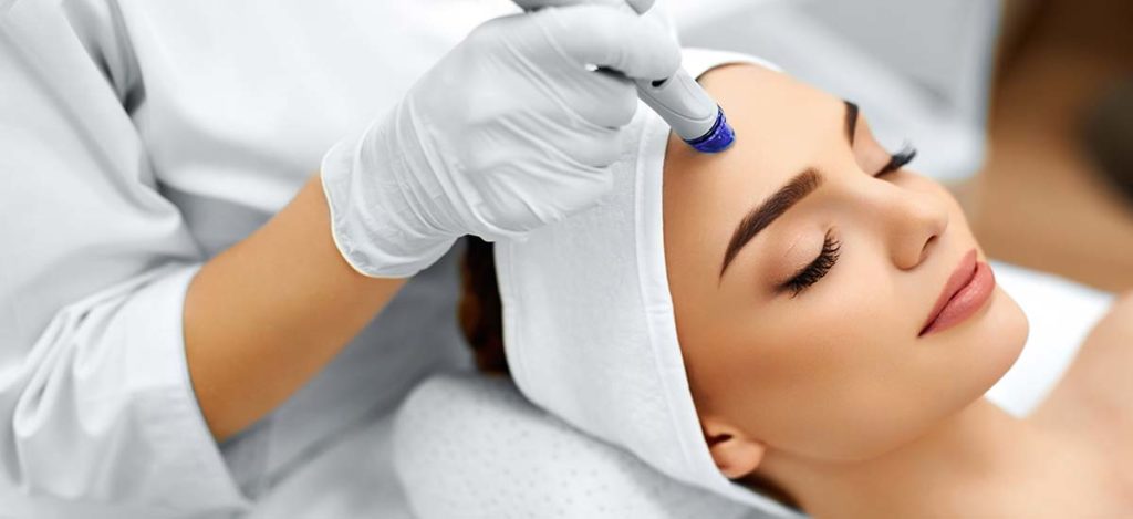 Woman receiving a hydrafacial from a skilled professional at KP Aesthetics.