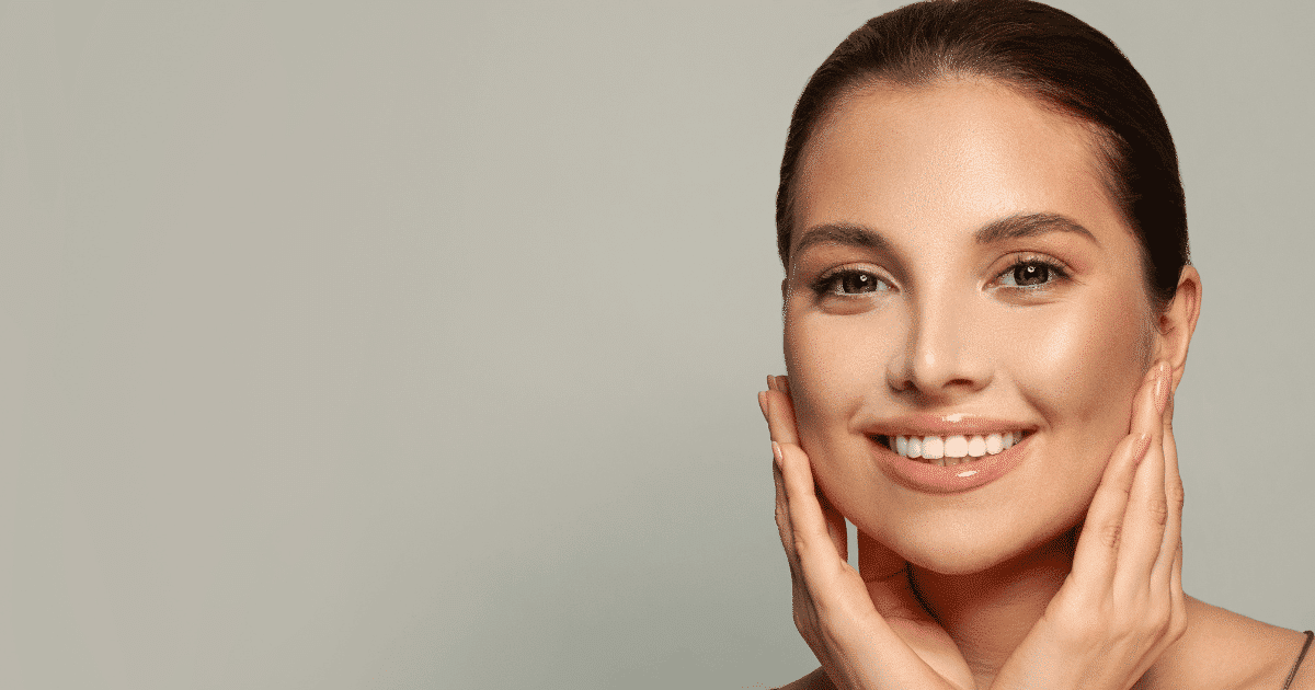 a beautiful woman smiling while holding her chin