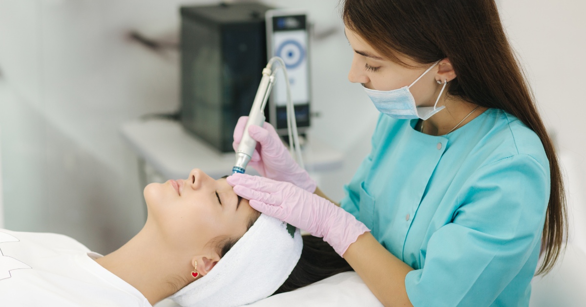 a skincare professional performing a facial treatment on a client in a clinic setting.