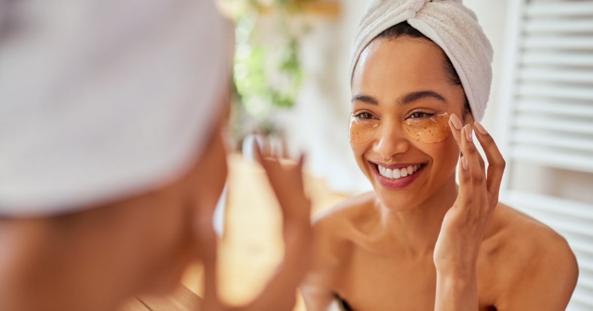patient applying a cool compress to the under-eye area at home, smiling comfortably