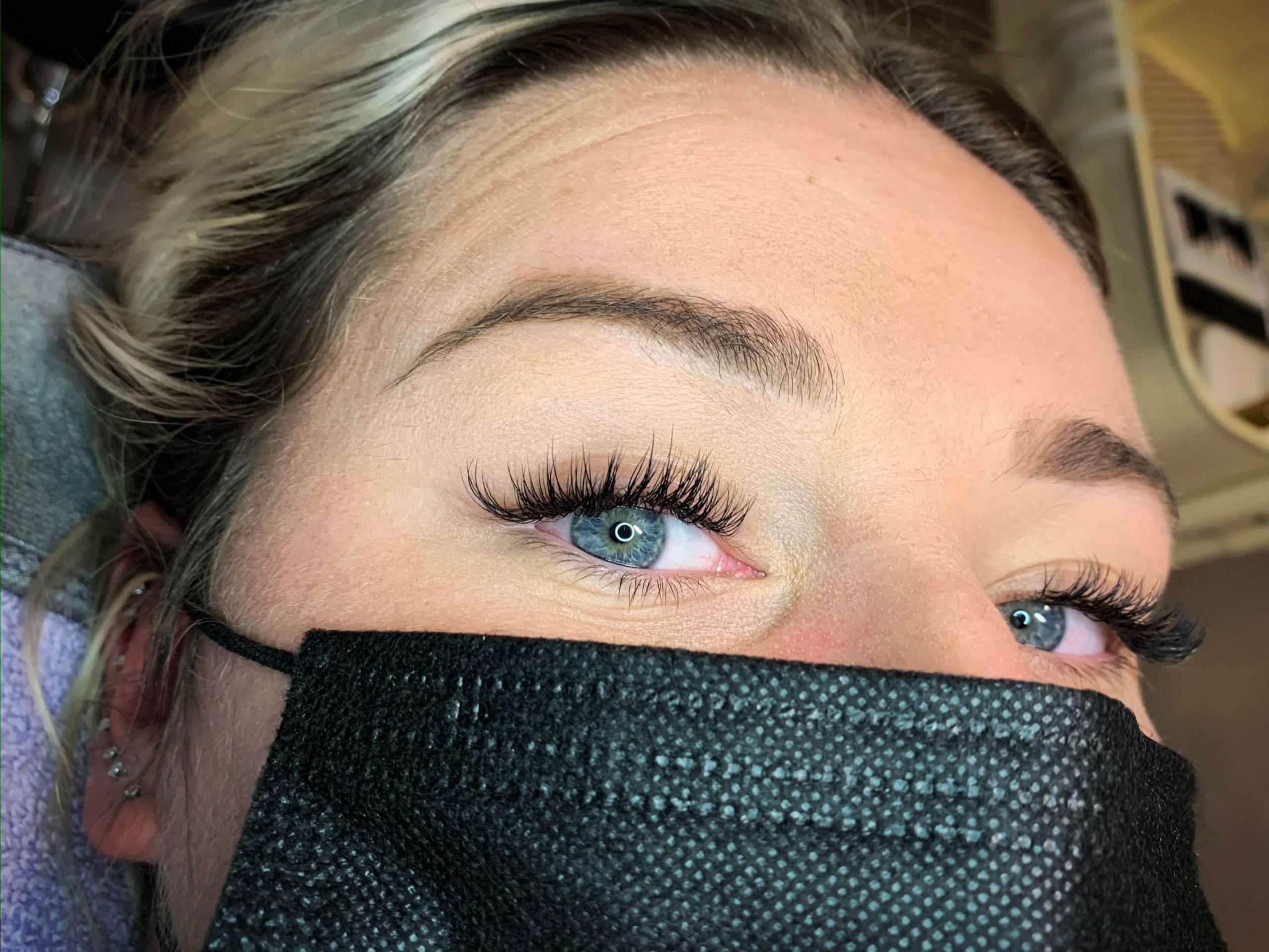 Woman's eyelashes before and after eyelash extension.